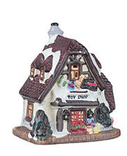 Petite maison de village de Noël illuminées